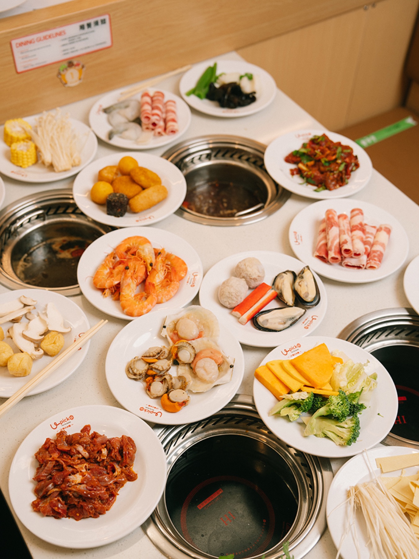 A generous selection of hotpot ingredients arranged around individual pots