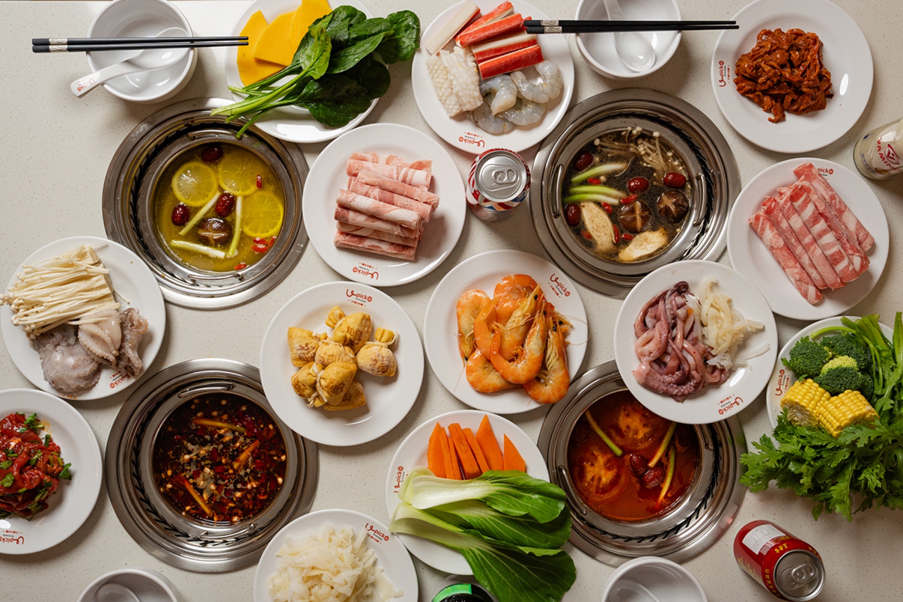 Overhead view of individual hot pots and a wide ingredient selection