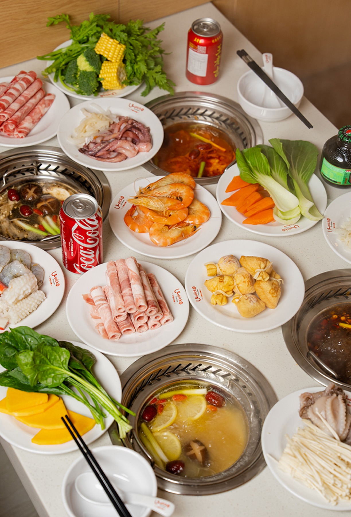 A table of individual hot pots and ingredients at U PICK
