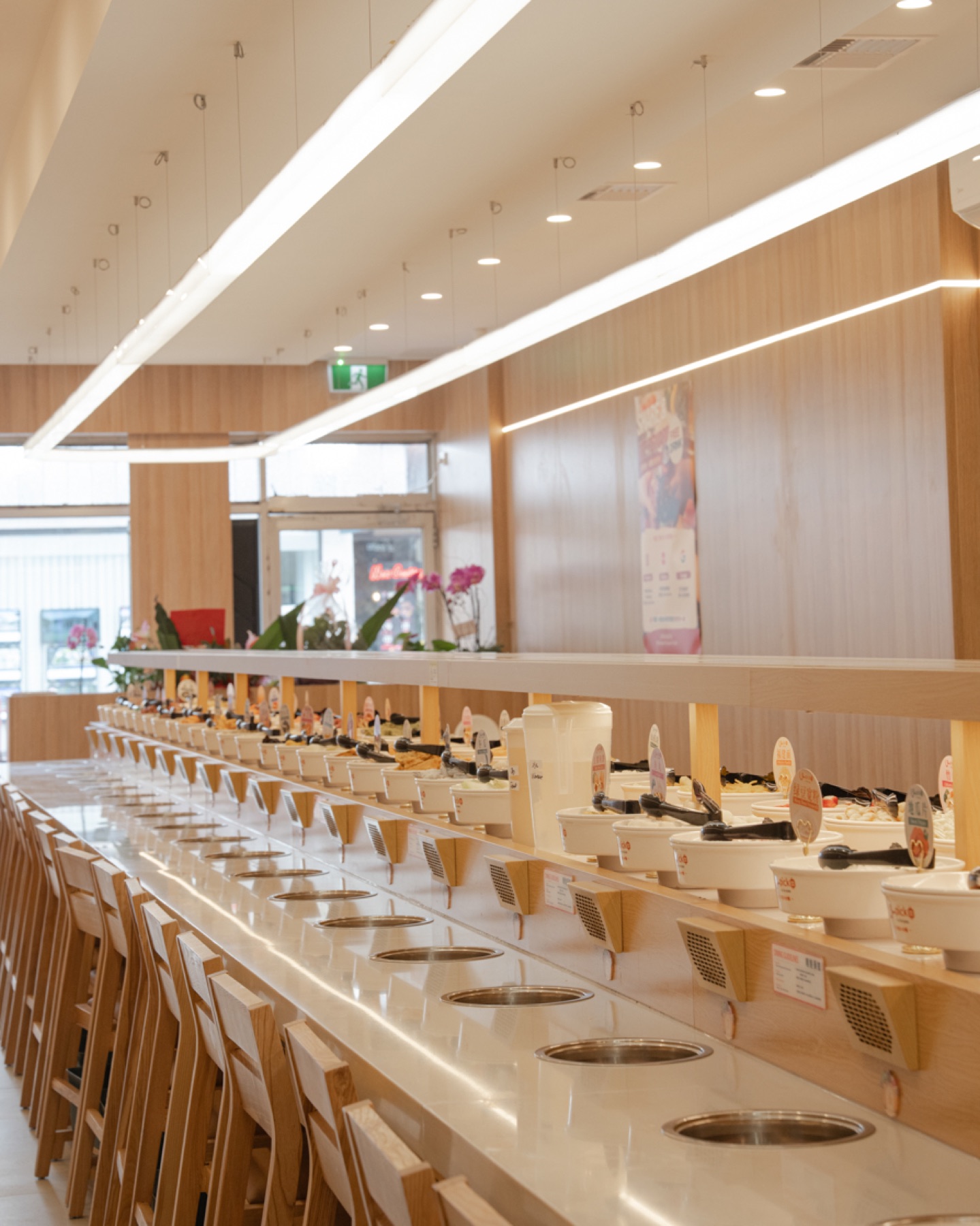 Rows of individual hotpot seats beside the conveyor belt